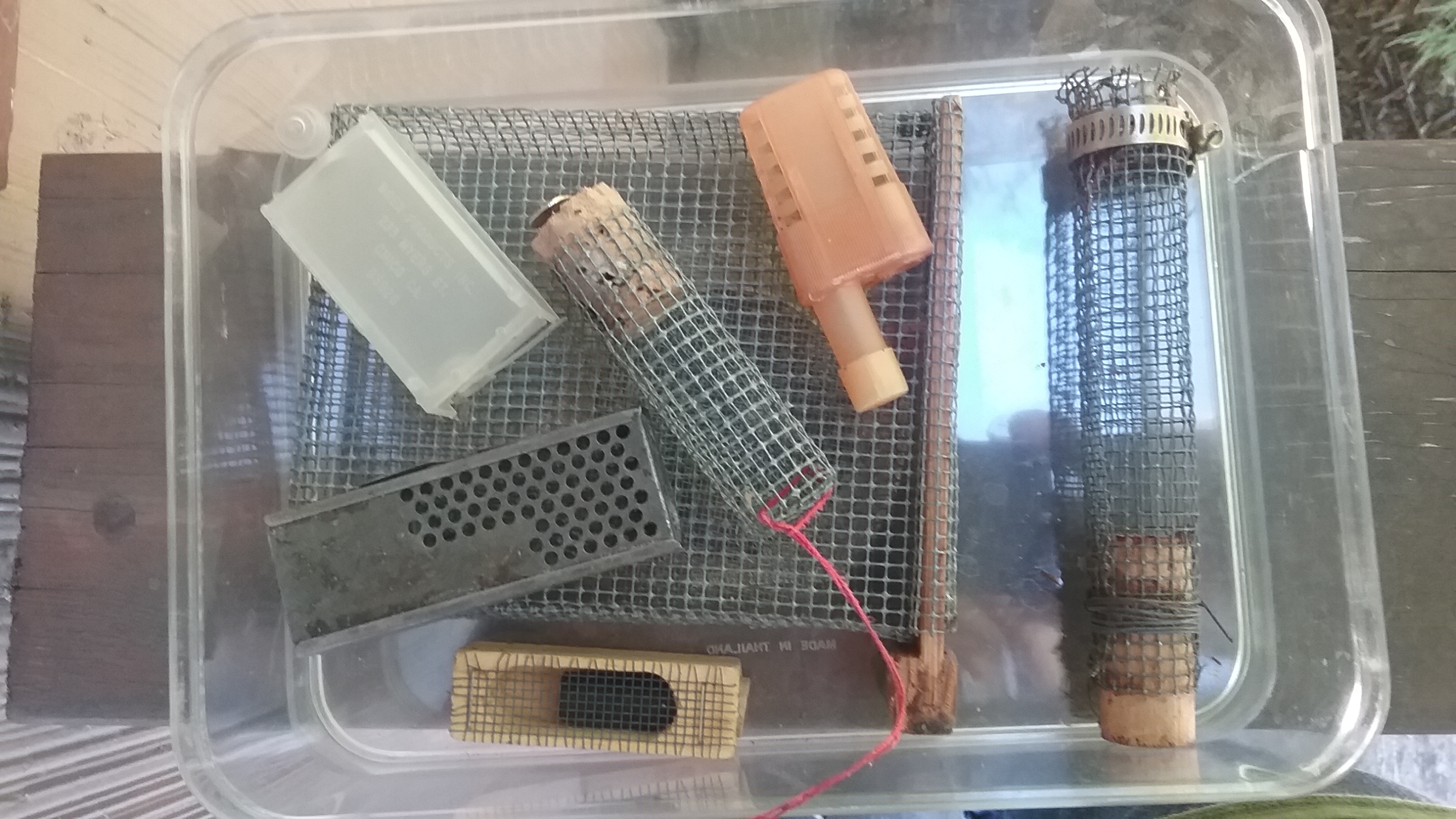 Selection of cages: homemade wire introduction cage; a wire  push-in cage (below); plastic and metal queen shipping cages; California shipping queen cage (top); photo by Dewey M. Caron